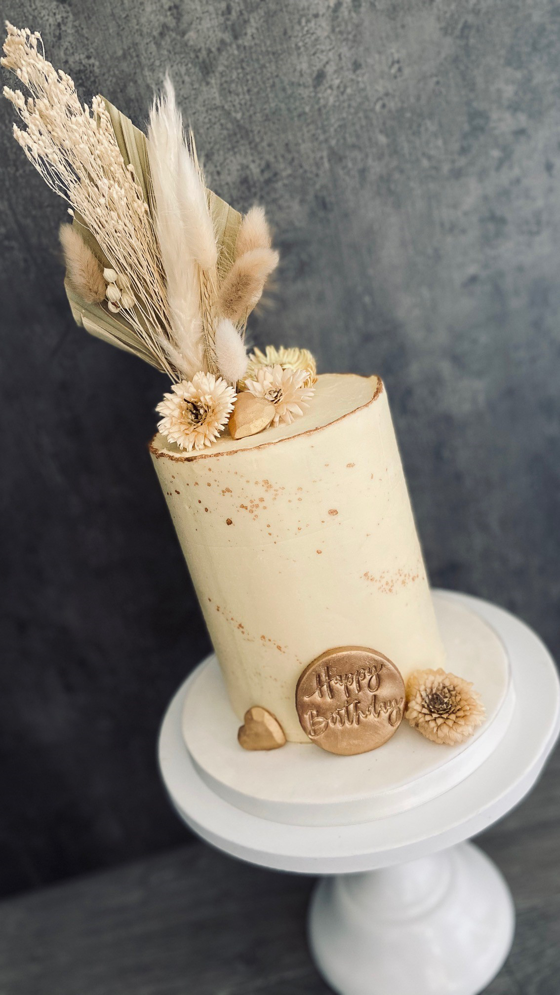 Stylish tall buttercream cake with dried flowers