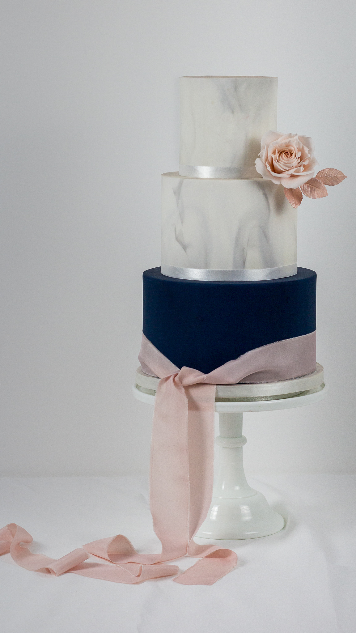 Navy blush pink and marbled wedding cake with sugar rose and silk ribbon